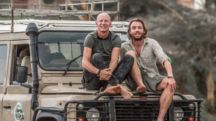 twee mannen op de motorkap van een safari van